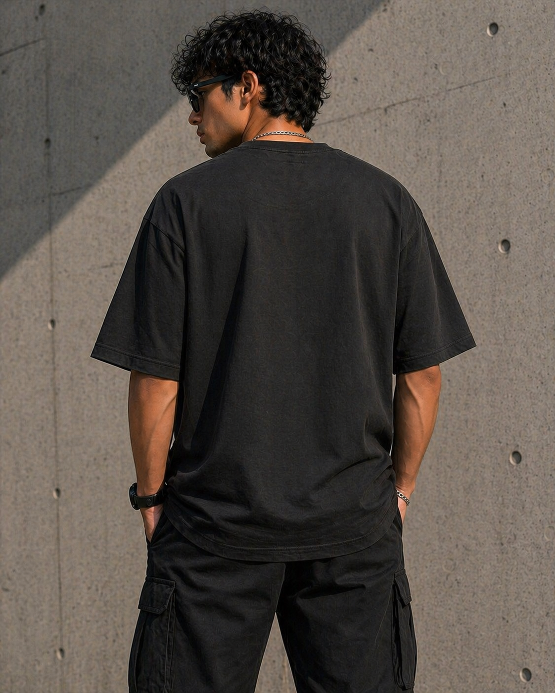 Back view of the black heavyweight t-shirt highlighting the clean structured fall and boxy streetwear fit.
