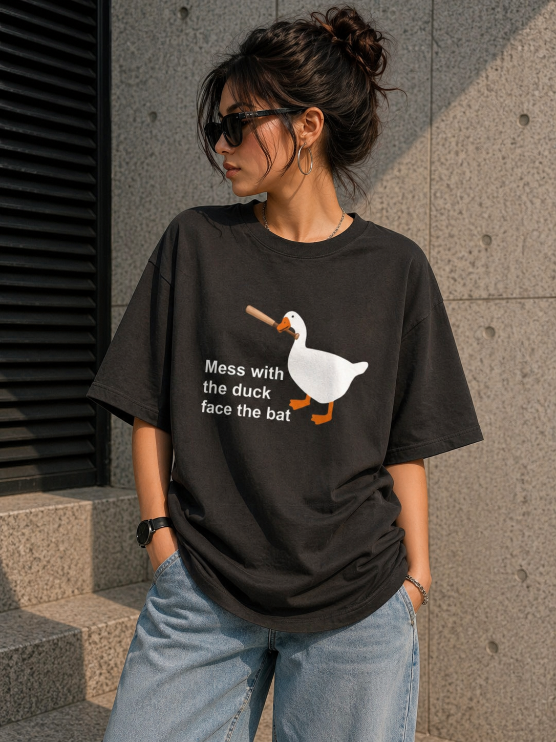 Front view of a black heavyweight oversized t-shirt with a humorous duck graphic for an edgy urban aesthetic.