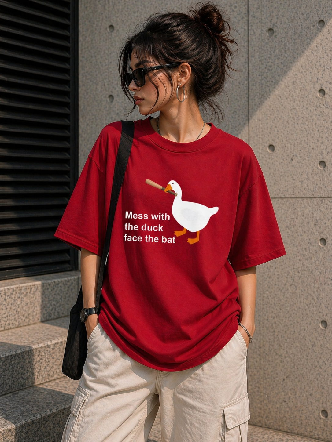 Woman wearing a bold red heavyweight oversized t-shirt with a quirky duck graphic, styled for a fun urban look.